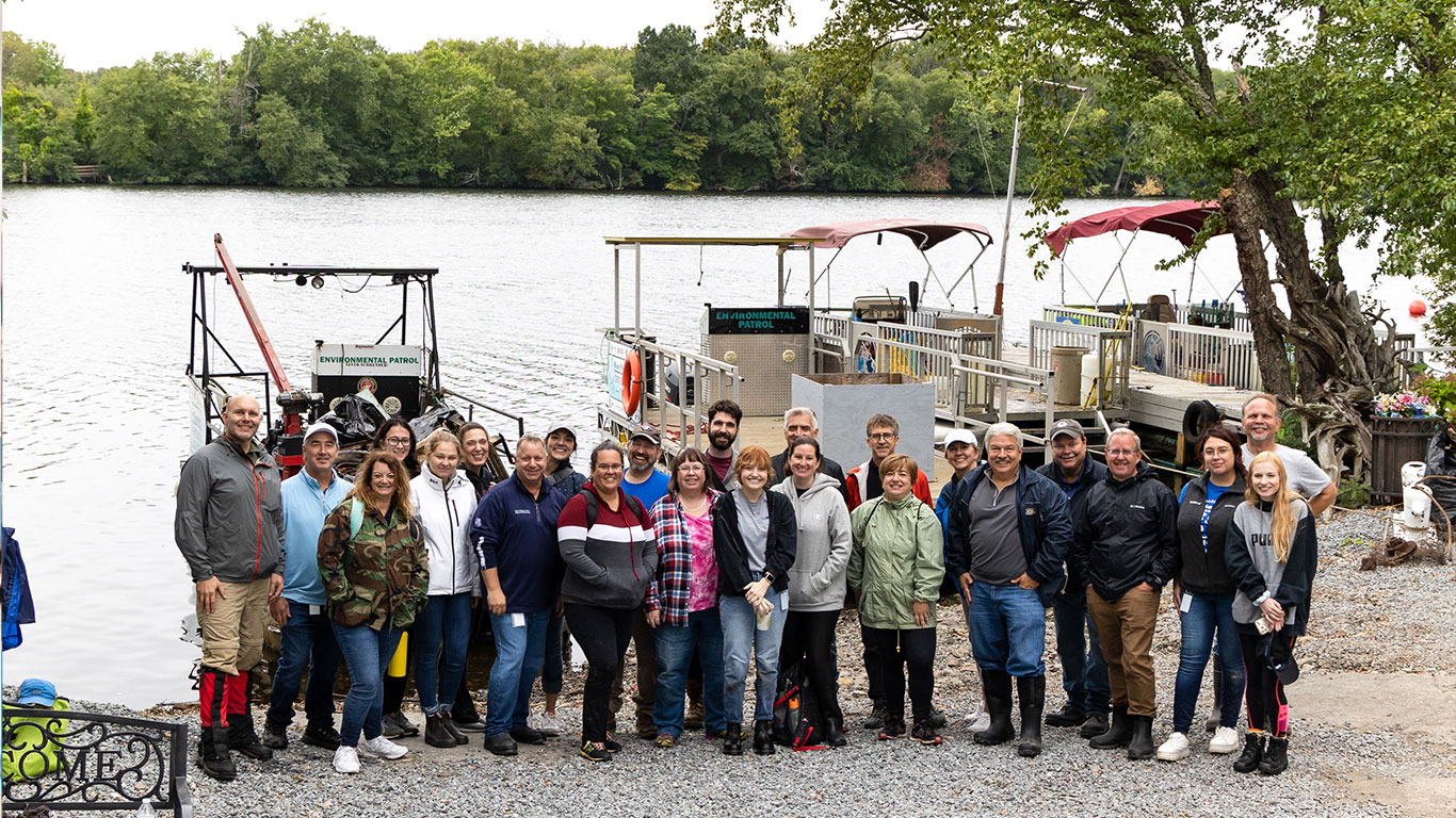 Watts employees standing in front of Merrimack River Clean Up event.